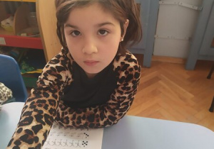 Dziewczynka wykonuje kartę pracy