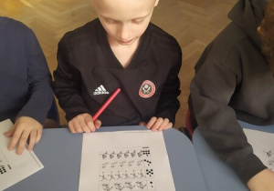 Chłopiec wykonuje kartę pracy