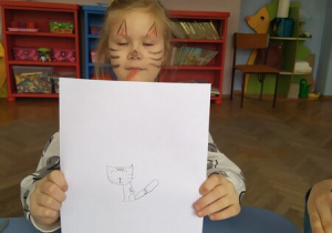 Dziewczynka pokazuje rysunek kota