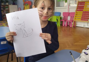 Dziewczynka pokazuje rysunek kota