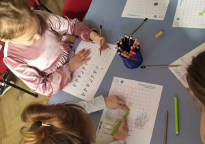 Dzieci pracuja przy stolikach