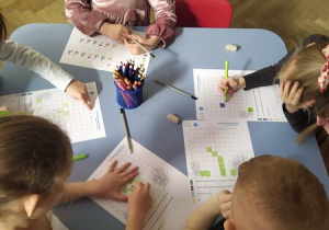 Dzieci pracuja przy stolikach