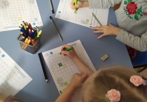 Dzieci pracuja przy stolikach
