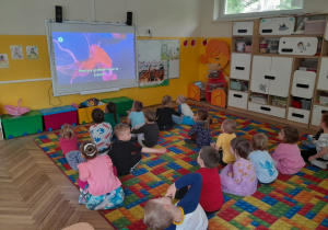 Dzieci oglądają film edukacyjny o zwierzętach