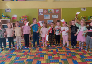 Dzieci machają polską flagą podczas śpiewania piosenki