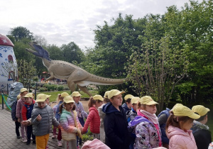Dzieci oglądają rzeźby dinozaurów