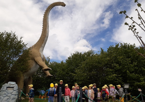 Dzieci oglądają rzeźby dinozaurów