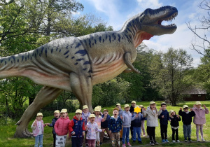 Dzieci oglądają rzeźby dinozaurów