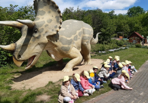 Dzieci oglądają rzeźby dinozaurów
