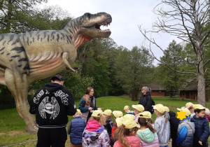 Dzieci oglądają rzeźby dinozaurów