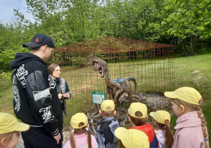 Dzieci oglądają rzeźby dinozaurów