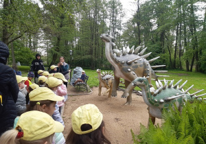 Dzieci oglądają rzeźby dinozaurów