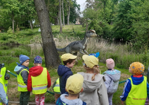 Dzieci oglądają rzeźby dinozaurów