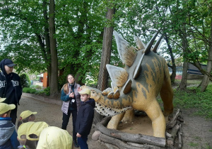 Dzieci oglądają rzeźby dinozaurów
