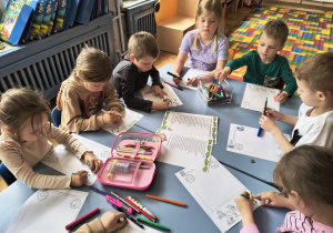 Dzieci wykonują kartę pracy.