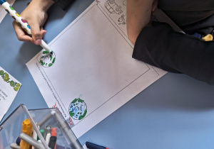 Dziecko koloruje planetę ziemię.