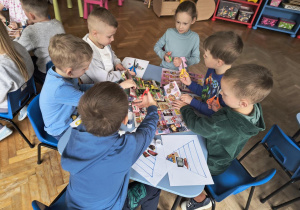 Dzieci wycinają produkty z gazetek.