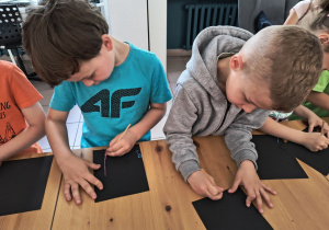 Dzieci tworzą obrazki na specjalnej kartce