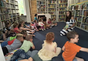 Pani bibliotekarka czyta dzieciom książkę.