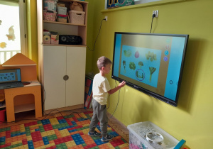 Dzieci rozwiązują zadania na tablicy multimedialnej