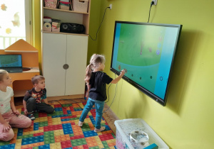 Dzieci rozwiązują zadania na tablicy multimedialnej