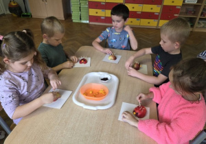 dzieci wykonują jeże z jabłuszek