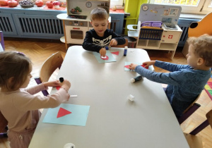 dzieci przyklejają elementy