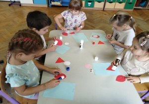 dzieci przyklejają elementy