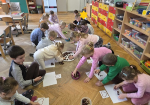 układają figury geometryczne z kasztanów