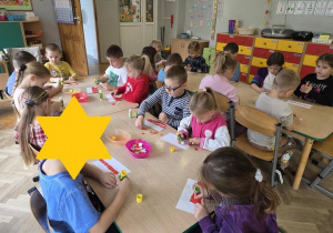 dzieci wykonują pracę plastyczną - flaga Polski