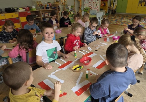 dzieci wykonują pracę plastyczną - flaga Polski