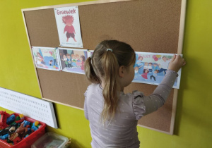 dziewczynka wiesza ilustrację