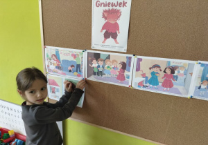 dziewczynka wiesza ilustrację do opowiadania