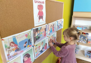 dziewczynka wiesza ilustrację do opowiadania