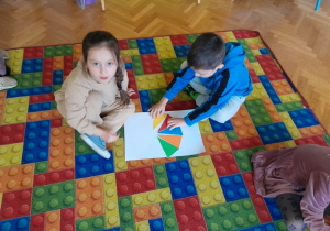 Dzieci układają parasolki z trójkątów