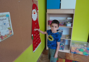 Chłopiec otwiera okienko kalendarza adwentowego