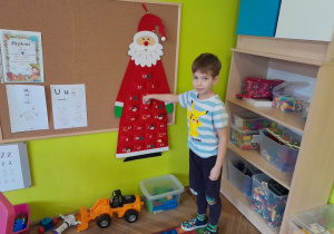 Chłopiec otwiera okienko kalendarza adwentowego