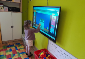 Dzieci wykonują zadanie na tablicy multimedialnej