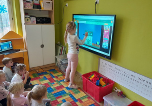 Dzieci wykonują zadanie na tablicy multimedialnej