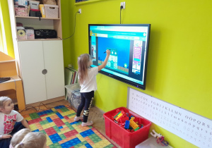 Dzieci wykonują zadanie na tablicy multimedialnej