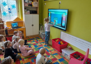 Dzieci wykonują zadanie na tablicy multimedialnej