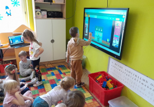 Dzieci wykonują zadanie na tablicy multimedialnej