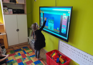 Dzieci wykonują zadanie na tablicy multimedialnej