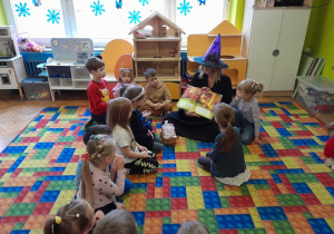 Dzieci słuchają książki czytanej przez zaproszonego gościa