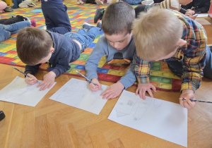 dzieci rysują zimowe piernikowe chatki