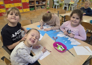 dzieci wycinają zimowe piernikowe chatki