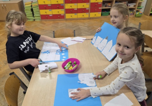 dzieci wycinają zimowe piernikowe chatki