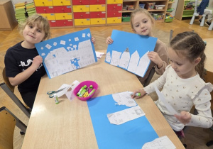 dzieci wycinają zimowe piernikowe chatki