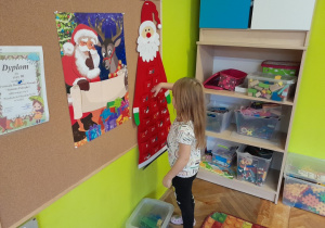 Dziecko zawiesza ozdobę na choince