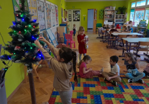 Dziecko zawiesza ozdobę na choince